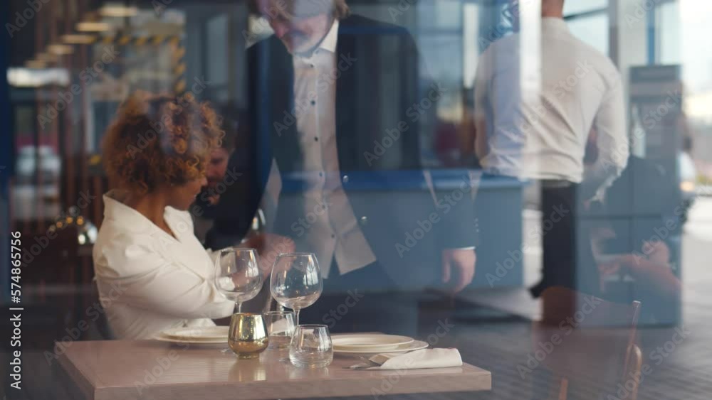 Multiethnic couple sitting indoors in restaurant, talking when having lunch. Realtime Multiethnic couple sitting indoors in restaurant, talking when having lunch. Realtime