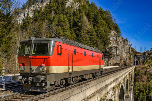 Electric locomotive crosses a stone viaduct on the semmering railway, Austria