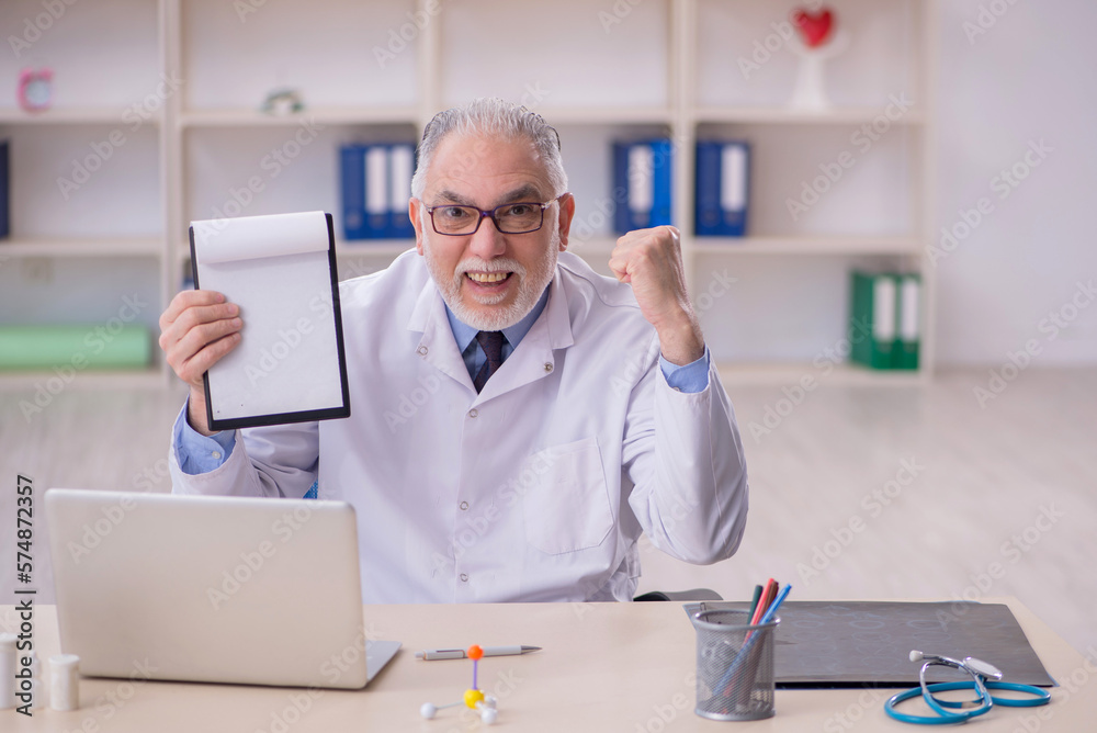 Obraz premium Old male doctor working in the clinic