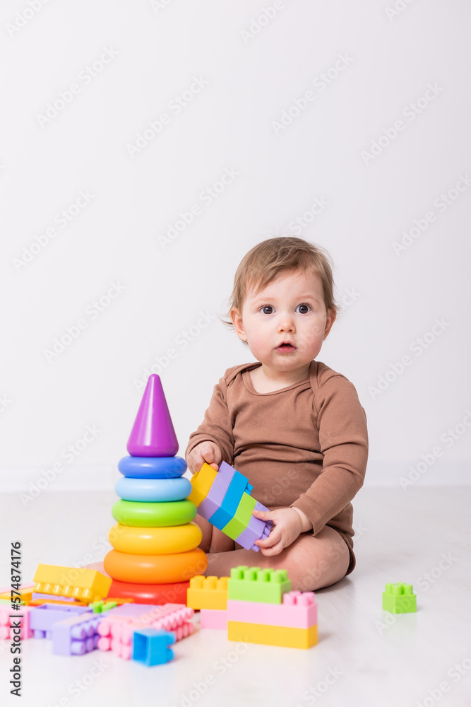 adorable baby in brown shirt playing with toys, card, banner, space for text adorable baby in brown shirt playing with toys, card, banner, space for text