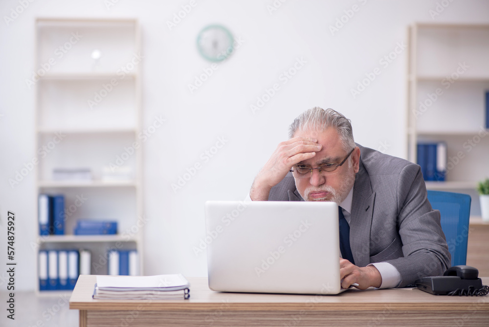 Old male employee working in the office Old male employee working in the office
