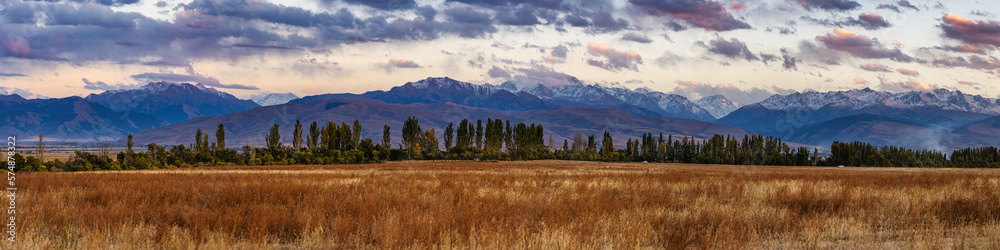 Wide panorama of autumn sunset view in mountains of Kyrgyzstan