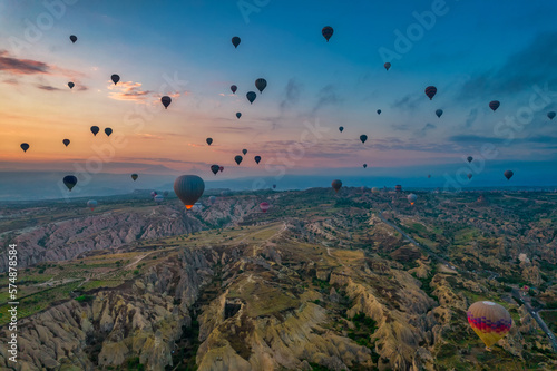 Amazing sunrise view of Cappadocia landscape in Turkey with lots of balloons flying