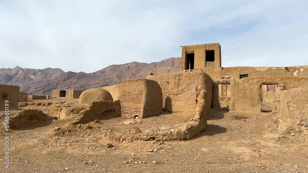 Ruins of desert dwelling settlement central Iran hot heat warm dry climate cloudy blue sky sun light morning traditional mud clay brick house architecture local design abandoned rural town wide view
