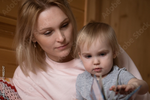 Mother reading book with child at home