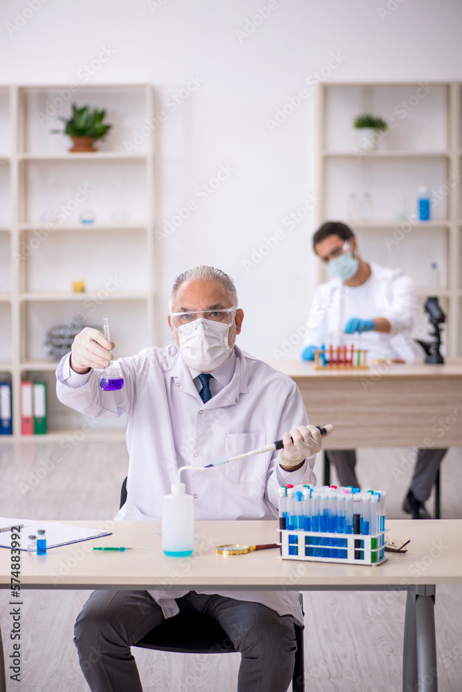 Two male chemist working at the lab Two male chemist working at the lab