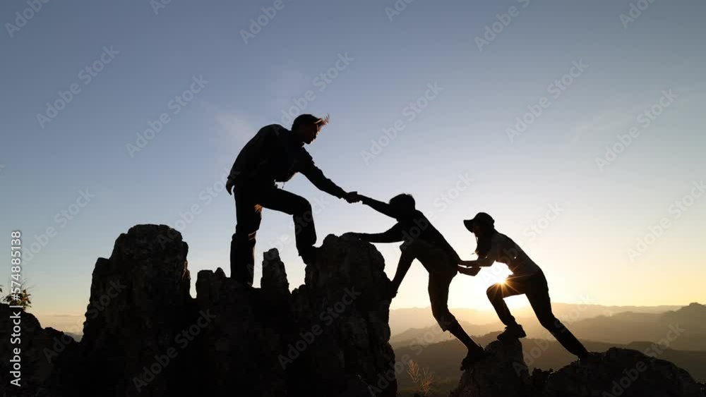 Silhouette of group team tourists lends helping hand climb cliffs mountains helping hand. teamwork helping hand business travel silhouette concept.  