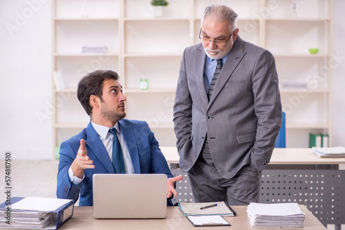 Two male colleagues working in the office © Elnur