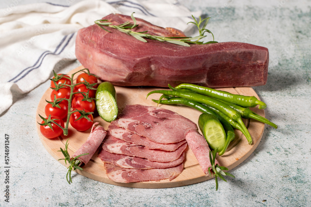 Smoked beef tongue. Sliced Smoked Veal Tongue on Wooden Cutting Board. Delicious smoked meat. Local name fume dana dil Smoked beef tongue. Sliced Smoked Veal Tongue on Wooden Cutting Board. Delicious smoked meat. Local name fume dana dil