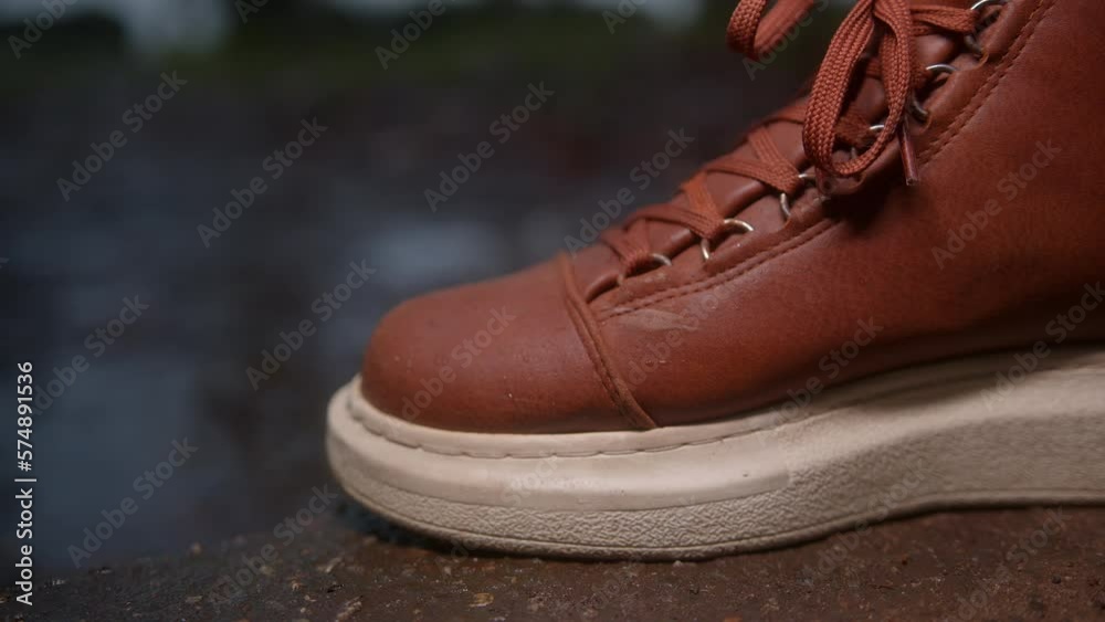 Close-Up of Brown Leather Shoes Treading on Wet Ground in the Rain Close-Up of Brown Leather Shoes Treading on Wet Ground in the Rain