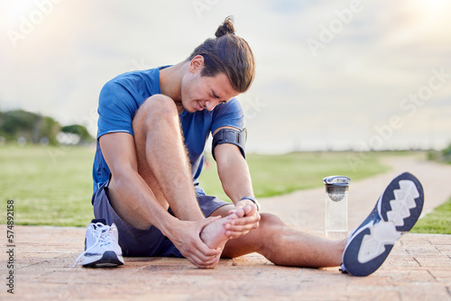 Fototapeta Naklejka Na Ścianę i Meble -  Fitness, sports injury and foot pain with man in park for muscle spasm, inflammation and joint problem. Running, workout and exercise with athlete and emergency for health, suffering and broken ankle