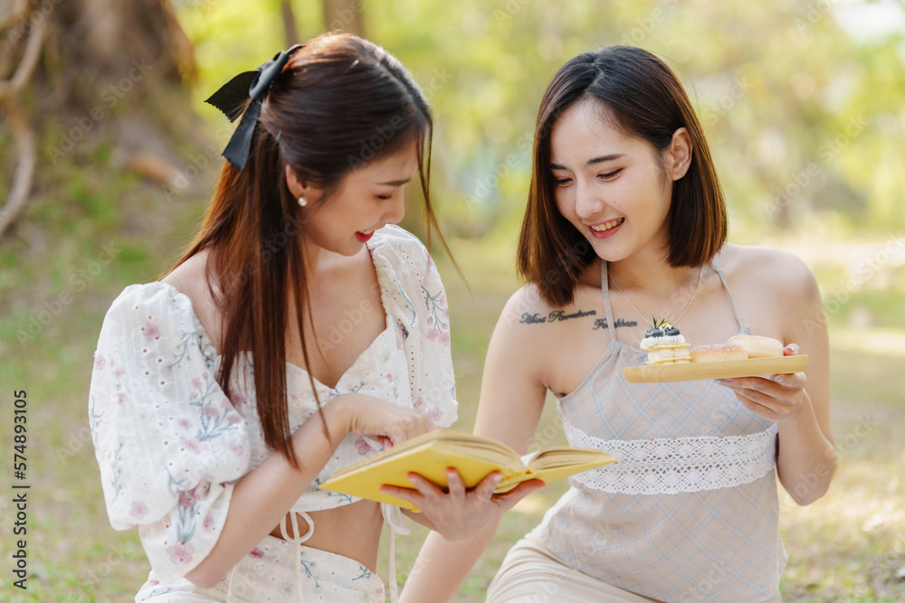 Two pretty asian friends woman picnic at park outdoor in relax time holiday, holiday recreation concept. Two pretty asian friends woman picnic at park outdoor in relax time holiday, holiday recreation concept.