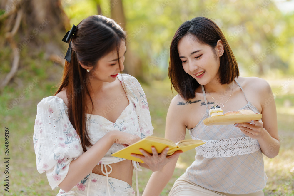 Two pretty asian friends woman picnic at park outdoor in relax time holiday, holiday recreation concept. Two pretty asian friends woman picnic at park outdoor in relax time holiday, holiday recreation concept.