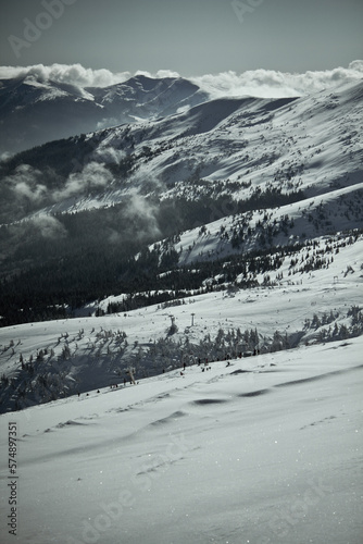 People skiing in ukrainian Carpathian mountains landscape photo. Nature scenery photography with clouds on background. Ambient light. High quality picture for wallpaper  travel blog  magazine  article