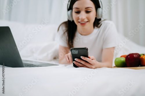 Beautiful woman resting and watching movie in bed at bedroom in morning Lifestyle at home