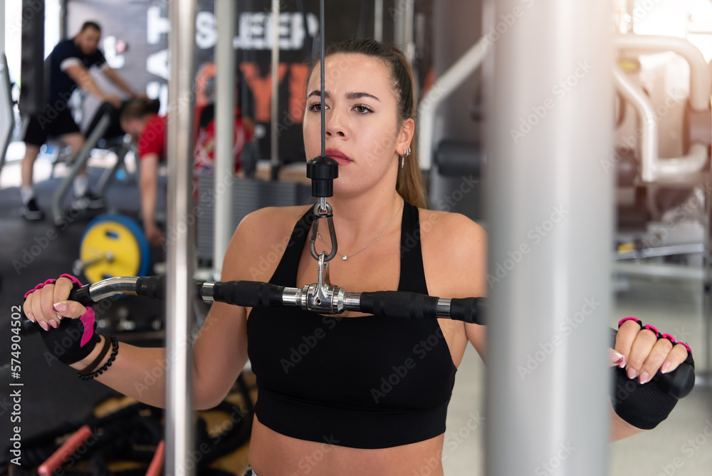 Young beautiful sporty woman is doing exercises in a fitness room. Gym workout Young beautiful sporty woman is doing exercises in a fitness room. Gym workout