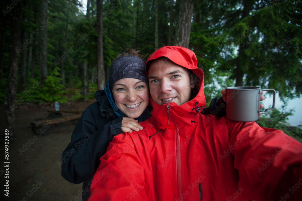 A couple take a selfie on a wet day while camping in Bowron Lake Provincial Park. A couple take a selfie on a wet day while camping in Bowron Lake Provincial Park.