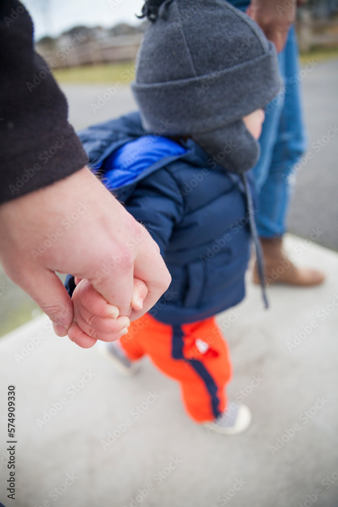 Parents holding hands of toddler Parents holding hands of toddler