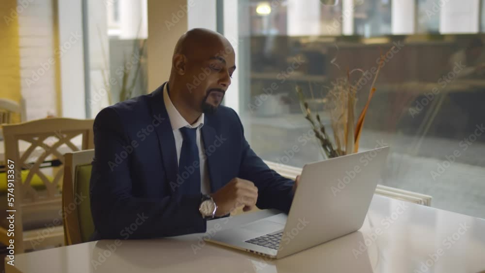 Stressed mature businessman use laptop in restaurant. Realtime Stressed mature businessman use laptop in restaurant. Realtime