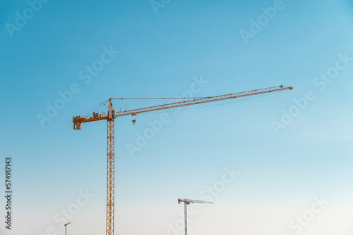 Construction crane in front of cloudless sunny blue sky