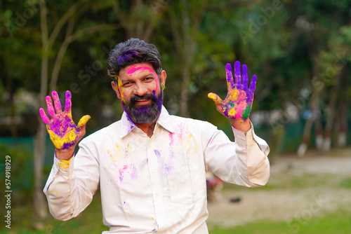 Indian man playing colors and celebrating holi festival.