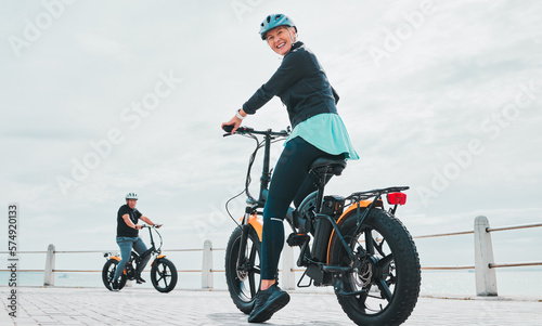 Fototapeta Naklejka Na Ścianę i Meble -  Mature woman, portrait or electrical bike helmet for future fitness, clean energy transport or sustainability travel. Happy person, technology or electric bicycle, head safety or eco friendly cycling