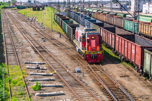 Shunting diesel locomotive and railway wagons. Railway wagons at the station for the transportation of goods. Rails at the railway station. Loaded wagons at the railway station.