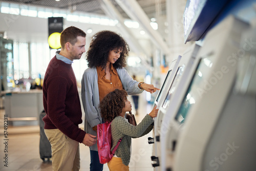 Obraz na plátně Family, self service and travel at airport for check in, registration or booking flight online together