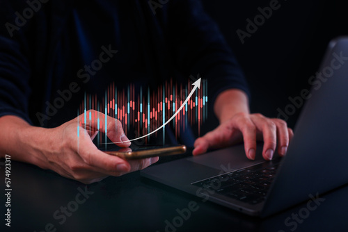 Hand of Businessman or trader touching showing a growing virtual hologram stock , Concept invest in trading.planning and strategy, Stock market, Business growth, progress or success concept.