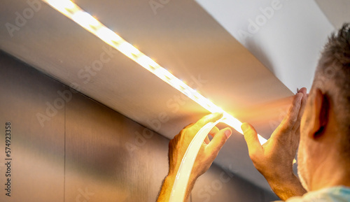 Obraz na płótnie Installing led strip for lighting correctly on the surface of the Cabinet on the kitchen set w salonie