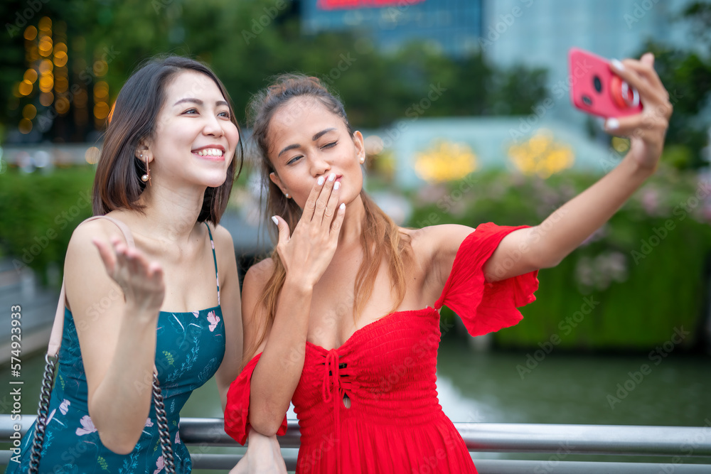 Two happy asian women taking selfies outdoor with the smartphone Two happy asian women taking selfies outdoor with the smartphone