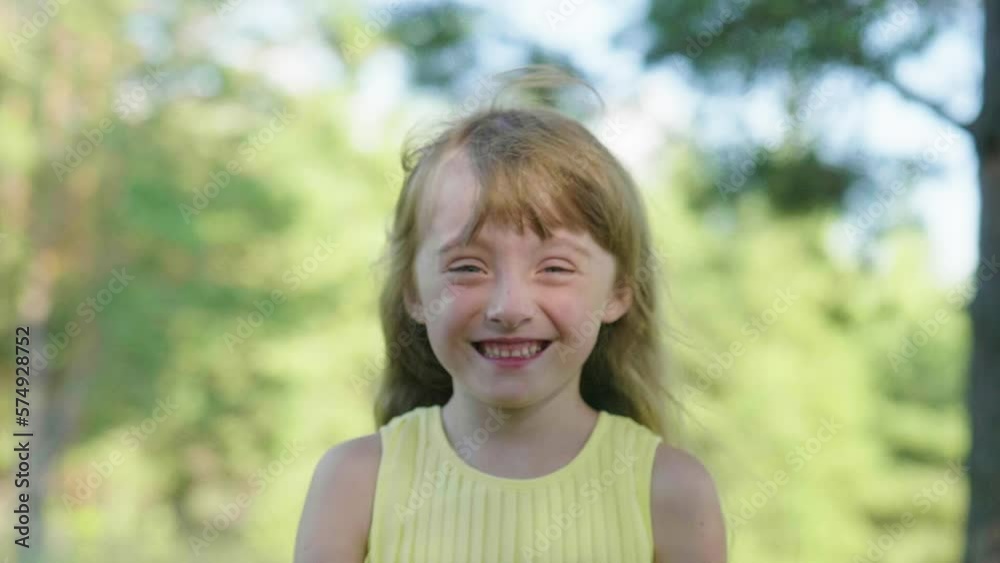 Outdoor Portrait Of A Funny Little Child. Little Happy Girl Laughs Looking at Camera. The Concept of a Carefree Happy Childhood Outdoor Portrait Of A Funny Little Child. Little Happy Girl Laughs Looking at Camera. The Concept of a Carefree Happy Childhood