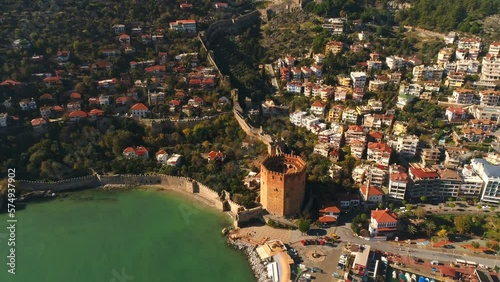 Aerial footage of flying copter over the charming sunny town Alanya overwashed by Mediterranean sea in Antalya province in Turkey. Beautiful panorama city view. Slow motion, 4k. photo