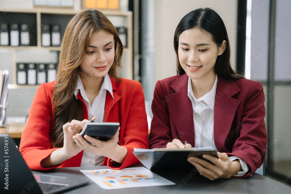 Asian women working with tablet and using a calculator to calculate the numbers of static in office. Finance accounting concept. Asian women working with tablet and using a calculator to calculate the numbers of static in office. Finance accounting concept.
