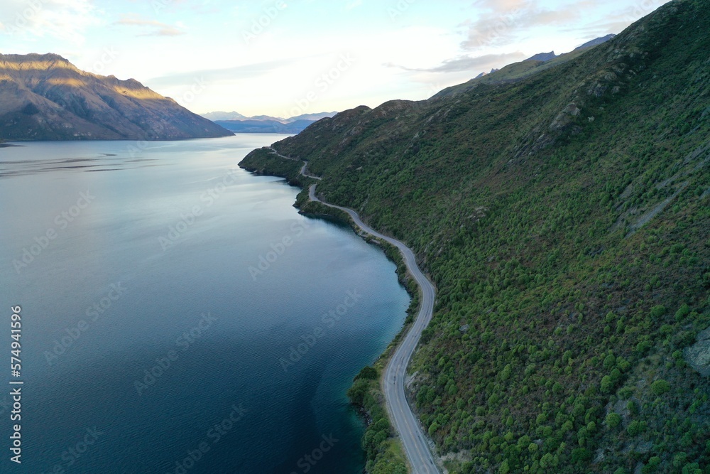 An aerial view of the road between lake and mountain