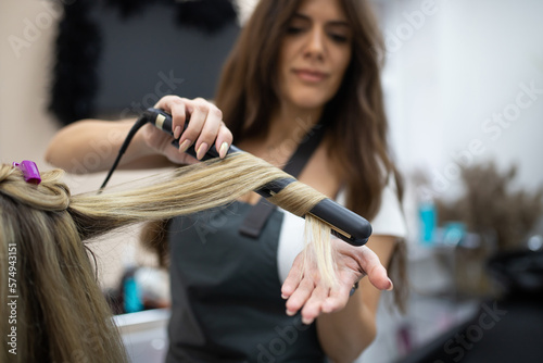 Woman getting curls from hairdressers.