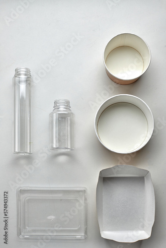 Various disposable tableware bottles and containers on a white background