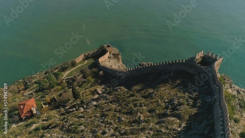 Aerial drone flight over old walls of Alanya fortress located on rocky hills and overwashed by Mediterranean sea. Slow motion, 4k. photo