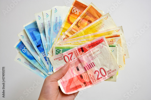 hands holding money - Israeli 20, 50,100 and 200 shekel bills New Israeli shekels 
