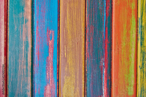 Wooden boards painted with a variety of bright colors. Bluish, yellow and orange vertical pattern.