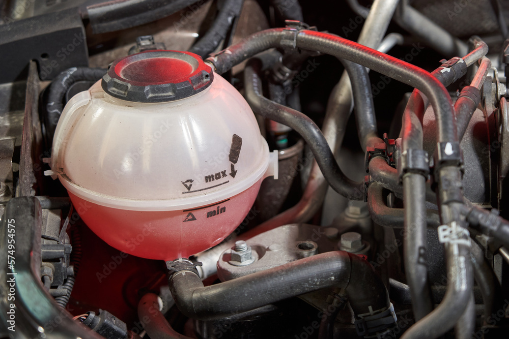 car plastic expansion tank with red antifreeze labeled max and min