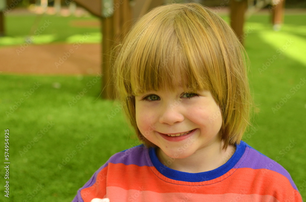 Portrait of a positive little boy. Face close-up. The child smiles sincerely. Space for text on a green background. Pleasant emotions Portrait of a positive little boy. Face close-up. The child smiles sincerely. Space for text on a green background. Pleasant emotions