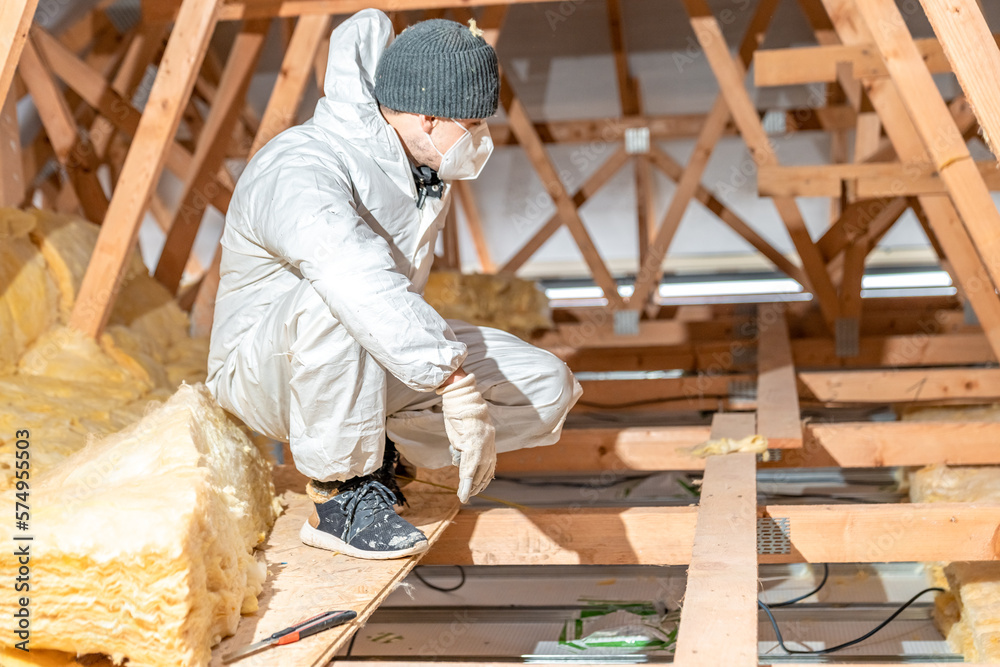 a worker in protective overalls works with glass wool a worker in protective overalls works with glass wool