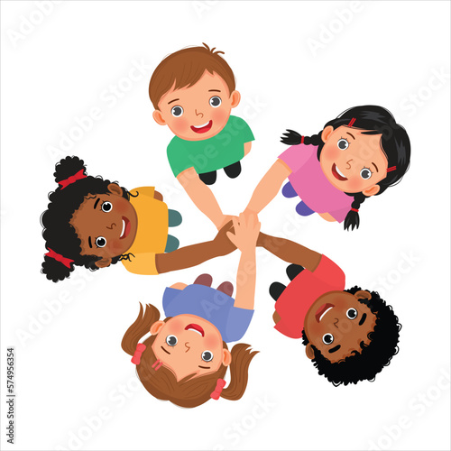 Group of happy children putting hands together in unity as a team