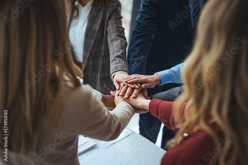 Large sea of hands. Group of business workers standing with hands together at the office. Symbol of teamwork, cooperation and unity. Stack of hands of men and woman.