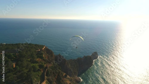 Parachute jumper is flying over Taurus Mountains range overwashed by Mediterranean sea in sunny Alanya, Antalya Province in Turkey. Beautiful nature footage from copter. photo