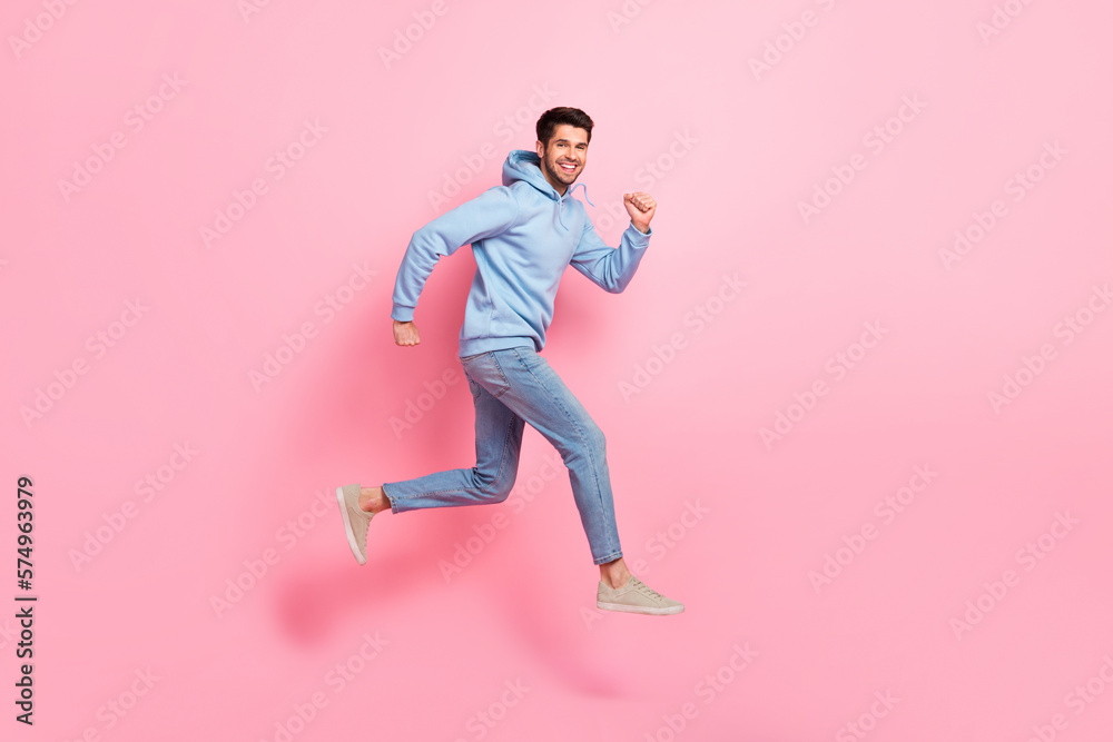 Full length profile side photo of cheerful man wear blue clothes running empty space store mall center isolated on pink color background