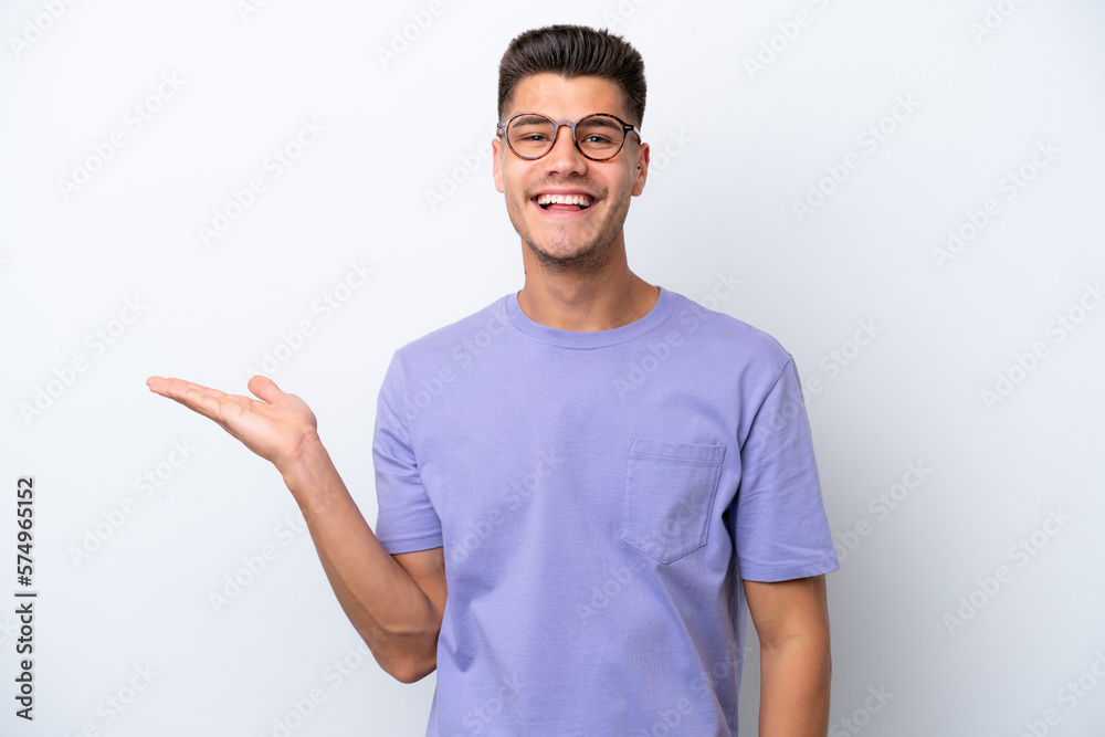 Young caucasian man isolated on white background holding copyspace imaginary on the palm to insert an ad Young caucasian man isolated on white background holding copyspace imaginary on the palm to insert an ad