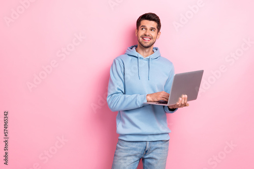 Photo of sweet dreamy man wear blue hoodie typing email modern device looking empty space isolated pink color background