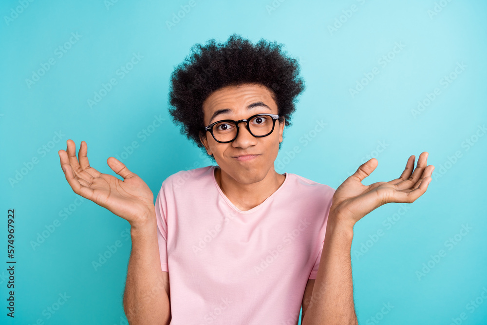 Closeup portrait of young funny confused man wear spectacles shrug shoulders no idea education problems isolated on aquamarine color background Closeup portrait of young funny confused man wear spectacles shrug shoulders no idea education problems isolated on aquamarine color background